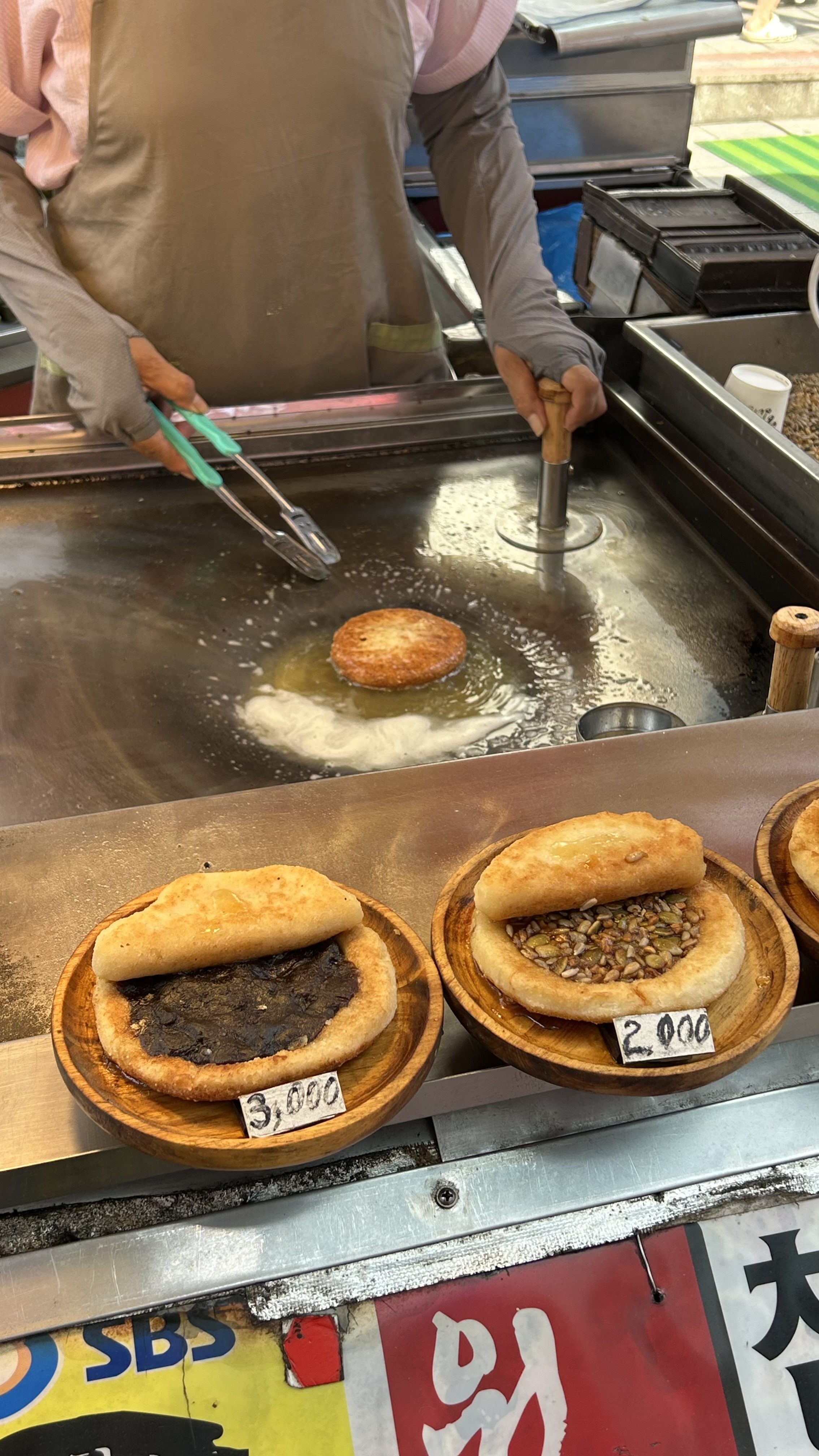 Vendor cooking fresh seed hotteok at a street stall in Busan