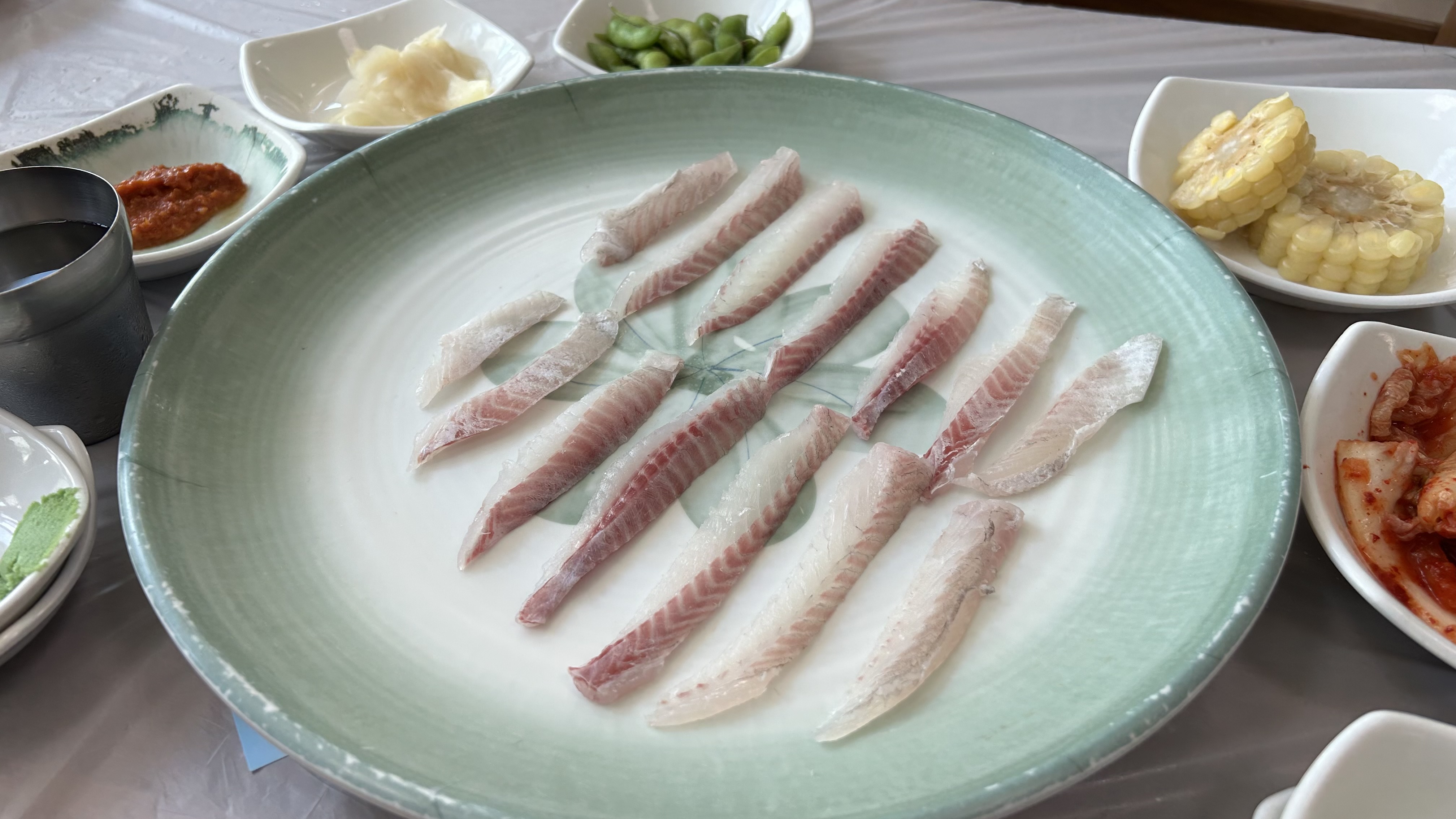 Fresh raw sashimi served at a table after buying seafood inside Jagalchi Market