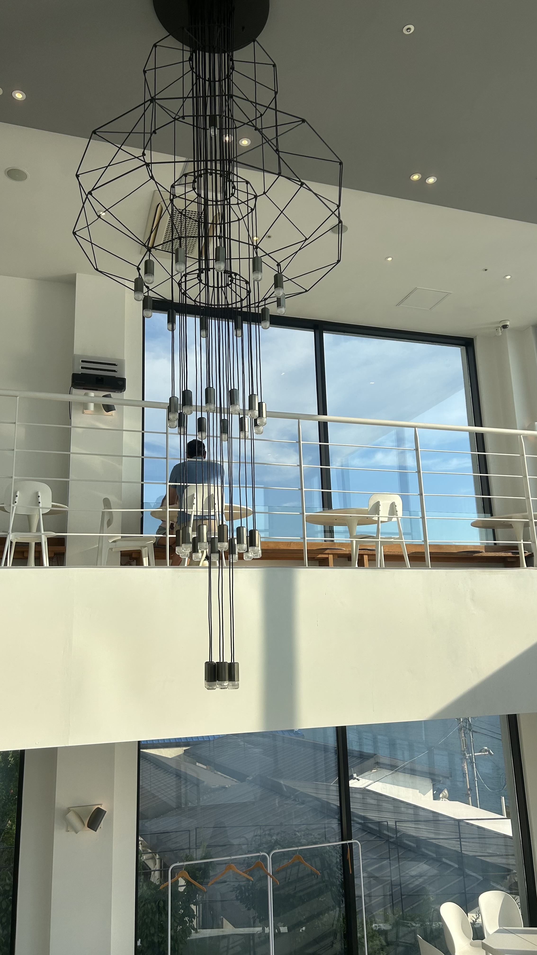 High ceiling and large chandelier-style lighting inside Aether cafe in Yeongdo, Busan
