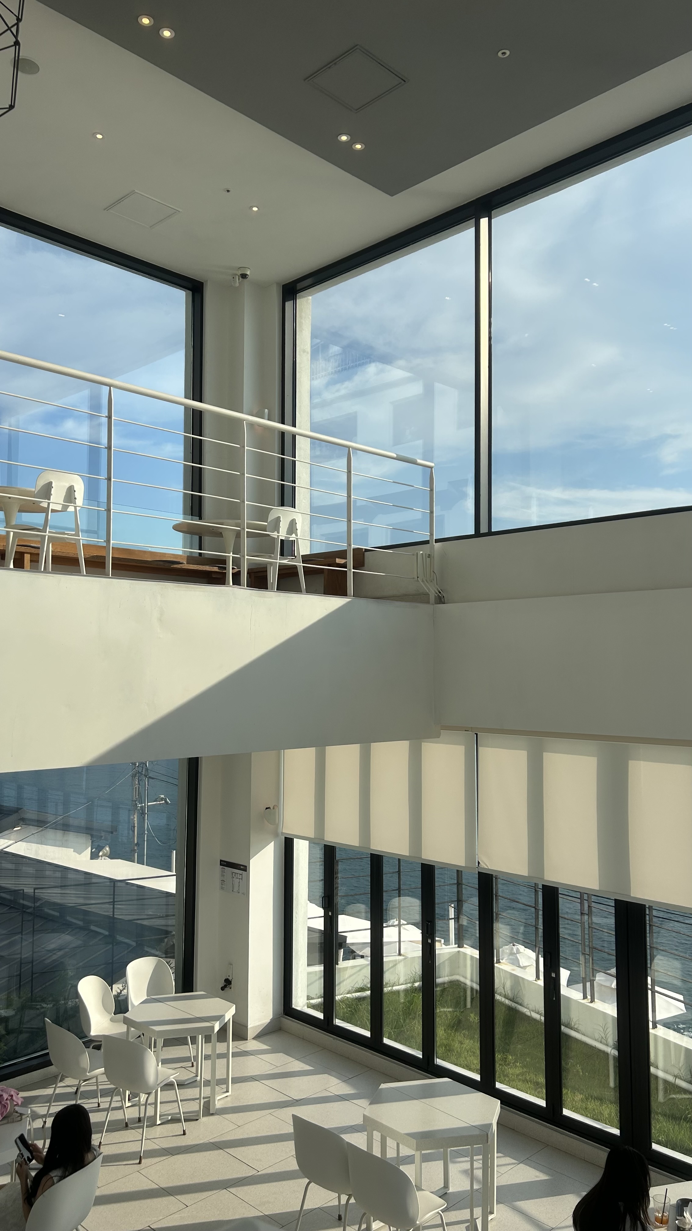 Tall ocean-view window inside Aether cafe near Huinnyeoul Culture Village